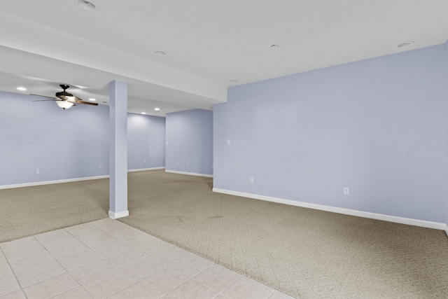 below grade area featuring light carpet, light tile patterned floors, baseboards, a ceiling fan, and recessed lighting