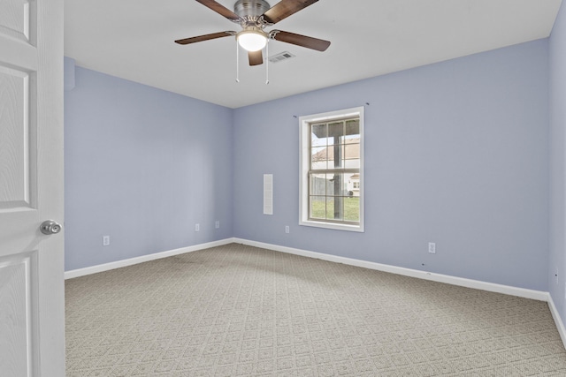 carpeted spare room featuring a ceiling fan, visible vents, and baseboards