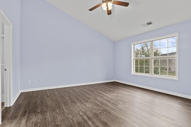 spare room featuring dark wood-style flooring, visible vents, and baseboards