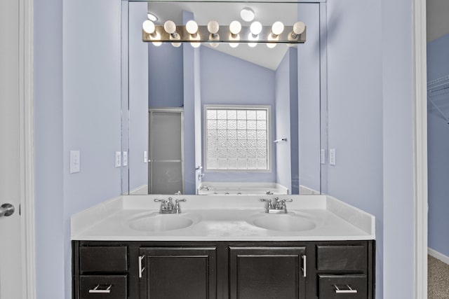 full bath featuring lofted ceiling, a spacious closet, a sink, and a garden tub