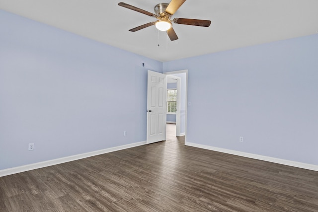 spare room featuring dark wood-style floors, baseboards, and a ceiling fan