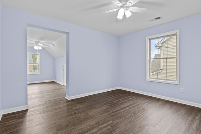 empty room featuring dark wood finished floors, lofted ceiling, visible vents, ceiling fan, and baseboards