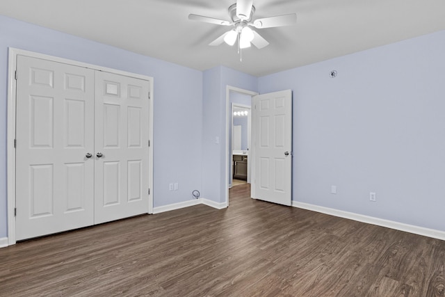 unfurnished bedroom with dark wood-style floors, a closet, and baseboards