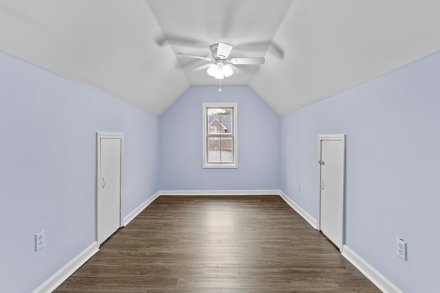 additional living space featuring a ceiling fan, lofted ceiling, dark wood-style flooring, and baseboards