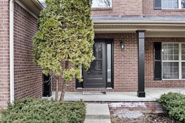 property entrance featuring brick siding and a porch