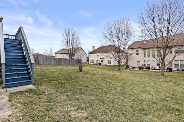 view of yard with fence and stairs