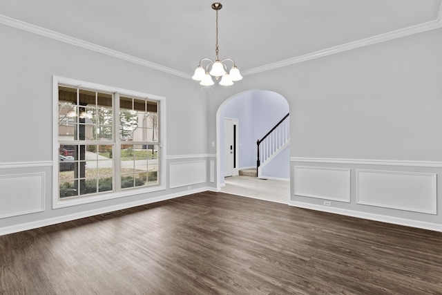 unfurnished dining area featuring arched walkways, dark wood finished floors, visible vents, stairway, and a chandelier