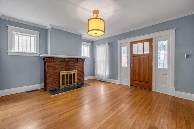 foyer with ornamental molding, light hardwood / wood-style floors, and plenty of natural light