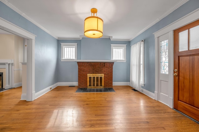 unfurnished living room featuring crown molding, light wood-type flooring, and a fireplace