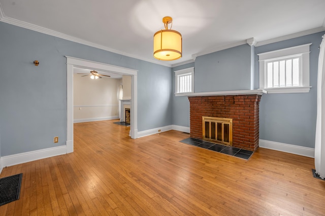 unfurnished living room with crown molding, ceiling fan, wood-type flooring, and a fireplace