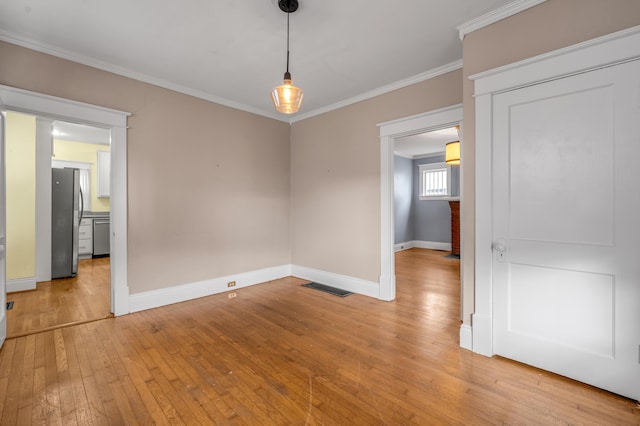 unfurnished dining area featuring ornamental molding and light hardwood / wood-style floors