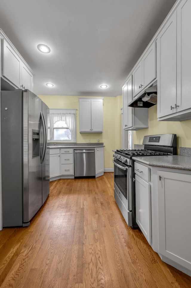 kitchen with stainless steel appliances, light wood-type flooring, and white cabinets