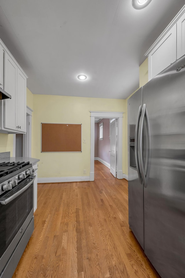 kitchen with white cabinetry, appliances with stainless steel finishes, and light hardwood / wood-style floors