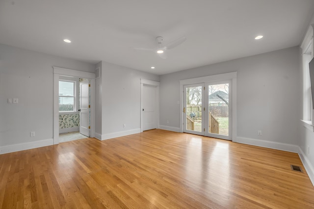 unfurnished room with ceiling fan, a wealth of natural light, and light hardwood / wood-style floors