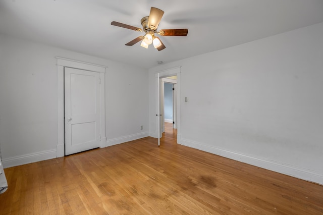 empty room with ceiling fan and light hardwood / wood-style flooring