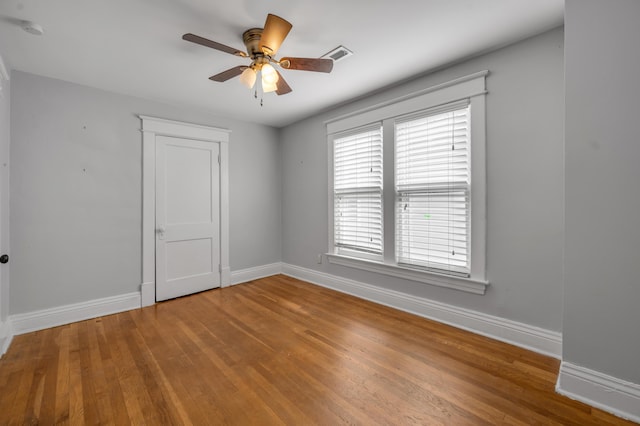 spare room with hardwood / wood-style flooring and ceiling fan