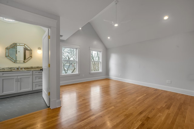 interior space with sink, wood-type flooring, high vaulted ceiling, and ceiling fan