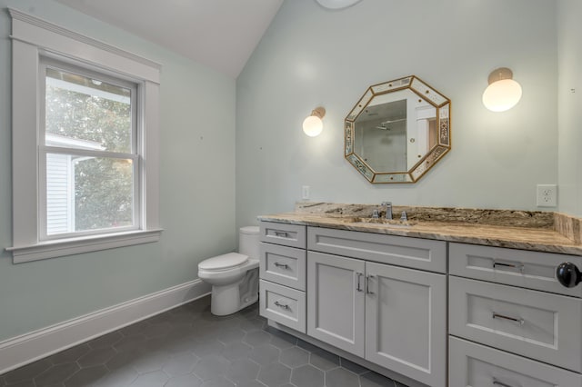 bathroom with vaulted ceiling, vanity, tile patterned floors, and toilet