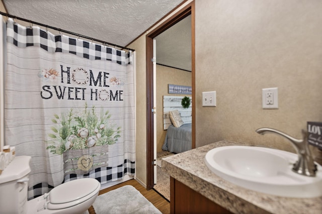 bathroom featuring vanity, hardwood / wood-style floors, toilet, and a textured ceiling