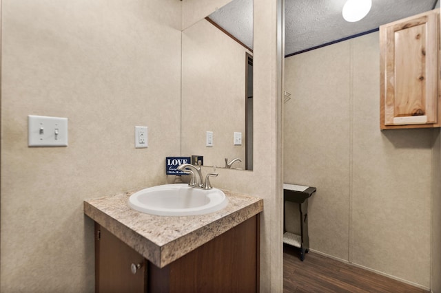 bathroom with hardwood / wood-style flooring, vanity, and a textured ceiling