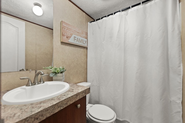 bathroom featuring vanity, ornamental molding, a textured ceiling, and toilet