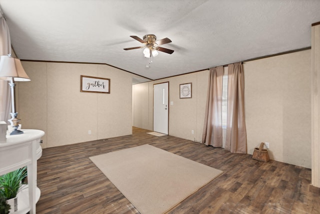 foyer featuring lofted ceiling, ceiling fan, dark hardwood / wood-style floors, ornamental molding, and a textured ceiling