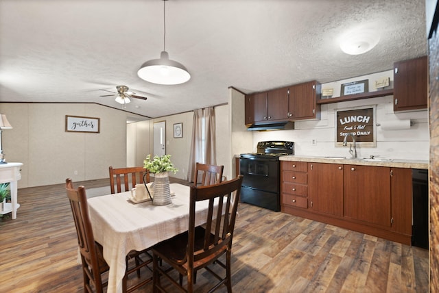 dining space featuring sink, vaulted ceiling, a textured ceiling, dark hardwood / wood-style floors, and ceiling fan