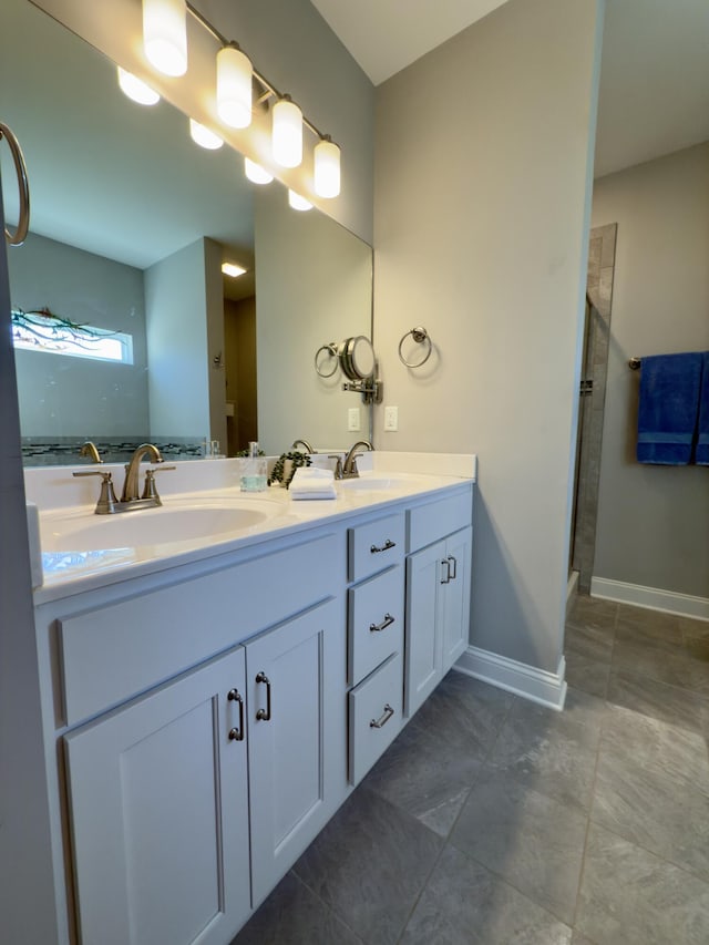 full bathroom with a sink, an enclosed shower, baseboards, and double vanity