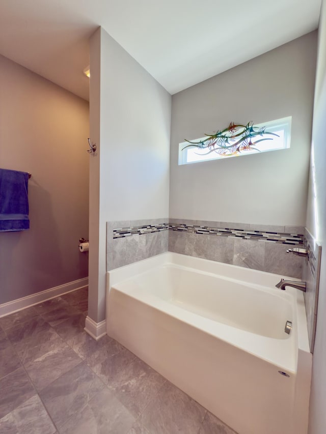 bathroom featuring baseboards and a garden tub