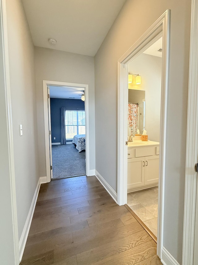 hall with baseboards and light wood-type flooring