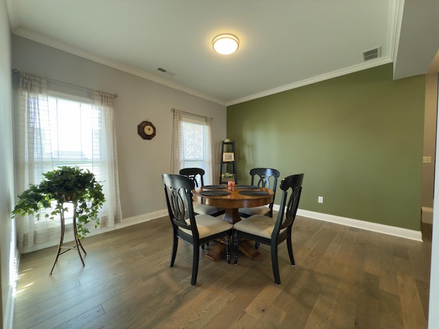 dining room with dark wood finished floors, baseboards, visible vents, and ornamental molding