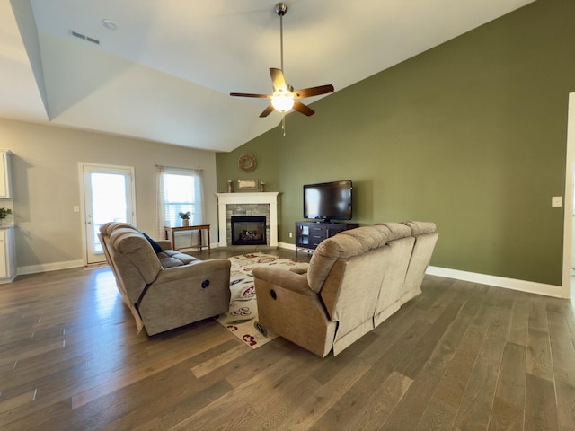 living room featuring dark wood finished floors, lofted ceiling, baseboards, and visible vents