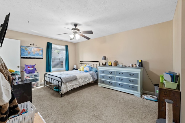 bedroom with ceiling fan, carpet floors, and a textured ceiling