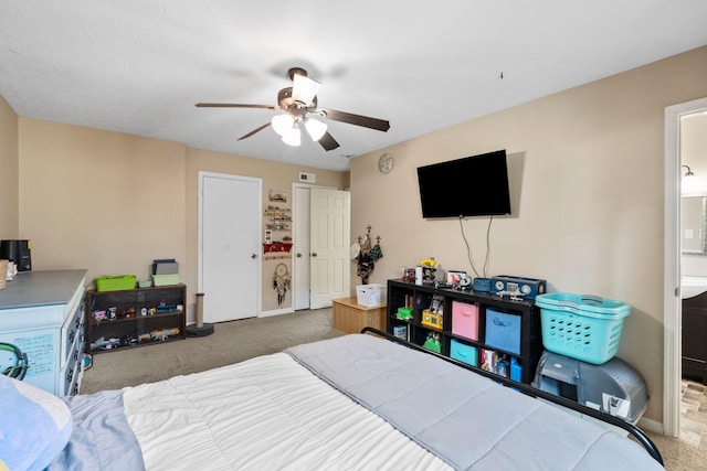 carpeted bedroom featuring ceiling fan and ensuite bath