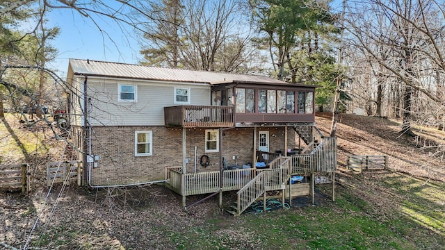 back of house with a wooden deck and a sunroom