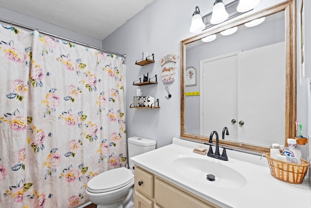 bathroom featuring a shower with curtain, vanity, toilet, and a textured ceiling