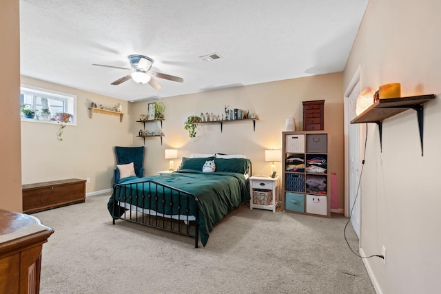 bedroom featuring ceiling fan, carpet floors, and a textured ceiling