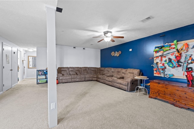 carpeted living room featuring ceiling fan and a textured ceiling