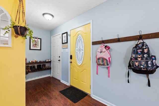 foyer entrance with dark wood-type flooring and a textured ceiling