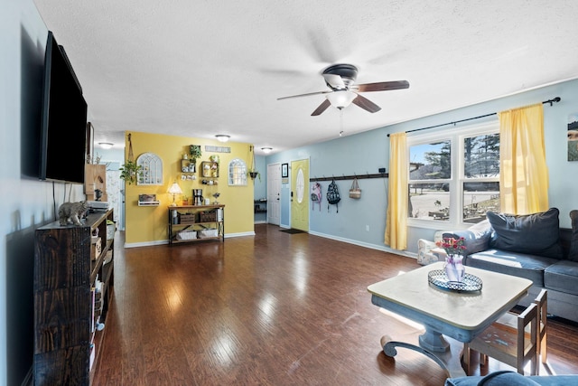 living room featuring ceiling fan, dark hardwood / wood-style floors, and a textured ceiling