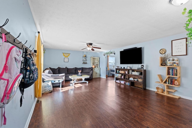 living room with ceiling fan, a textured ceiling, and dark hardwood / wood-style flooring