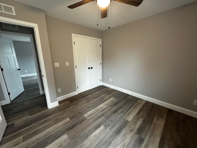 unfurnished bedroom featuring dark hardwood / wood-style flooring, a closet, and ceiling fan