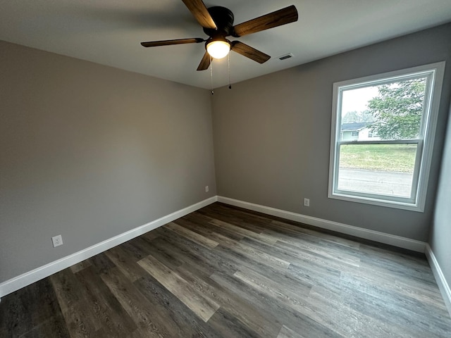 spare room featuring dark wood-type flooring and ceiling fan