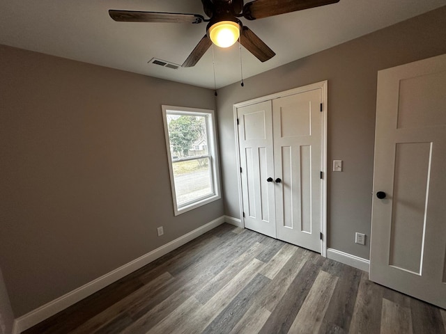 unfurnished bedroom with hardwood / wood-style floors, a closet, and ceiling fan