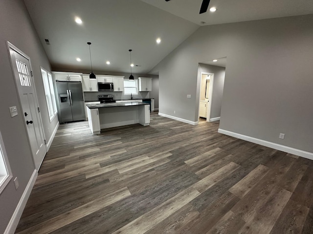 kitchen featuring stainless steel appliances, a center island, white cabinets, dark hardwood / wood-style flooring, and decorative light fixtures