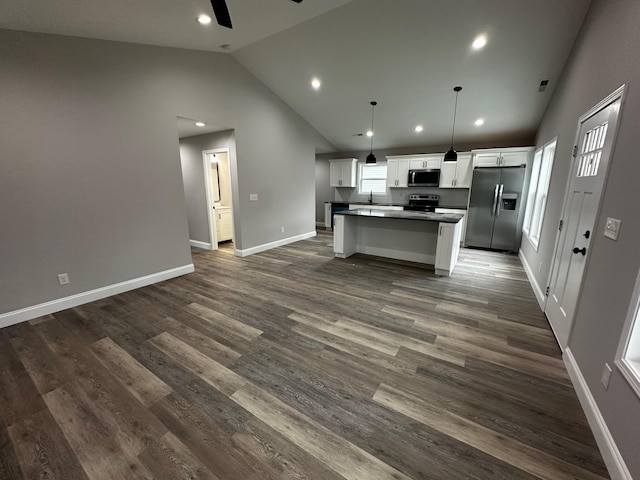 kitchen featuring appliances with stainless steel finishes, white cabinetry, hanging light fixtures, a center island, and dark wood-type flooring