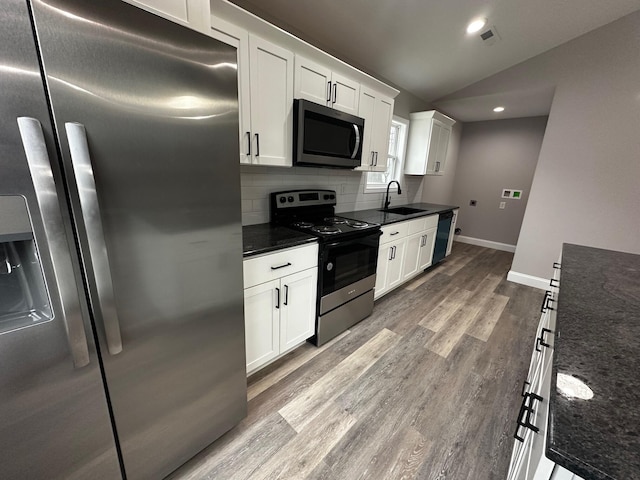 kitchen featuring white cabinetry, lofted ceiling, sink, backsplash, and stainless steel appliances