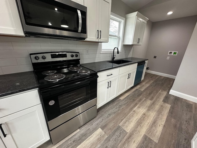 kitchen with sink, hardwood / wood-style flooring, white cabinets, and appliances with stainless steel finishes