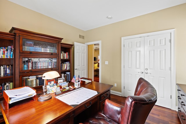 office area featuring dark wood-style flooring, visible vents, and baseboards