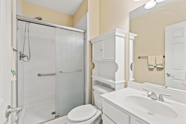 bathroom featuring toilet, a stall shower, and vanity